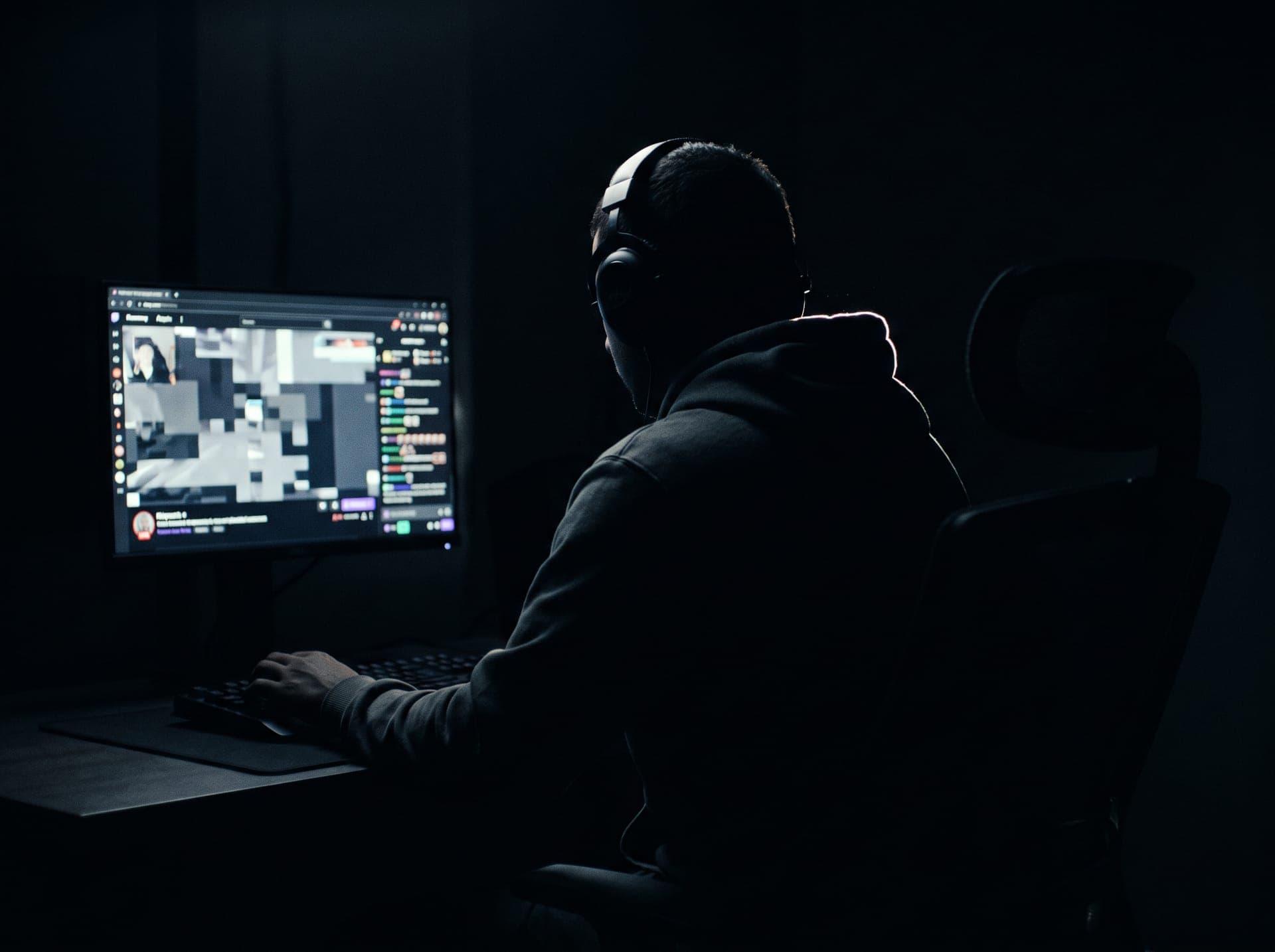 Streamer with headset in a dark room lit by orange neon