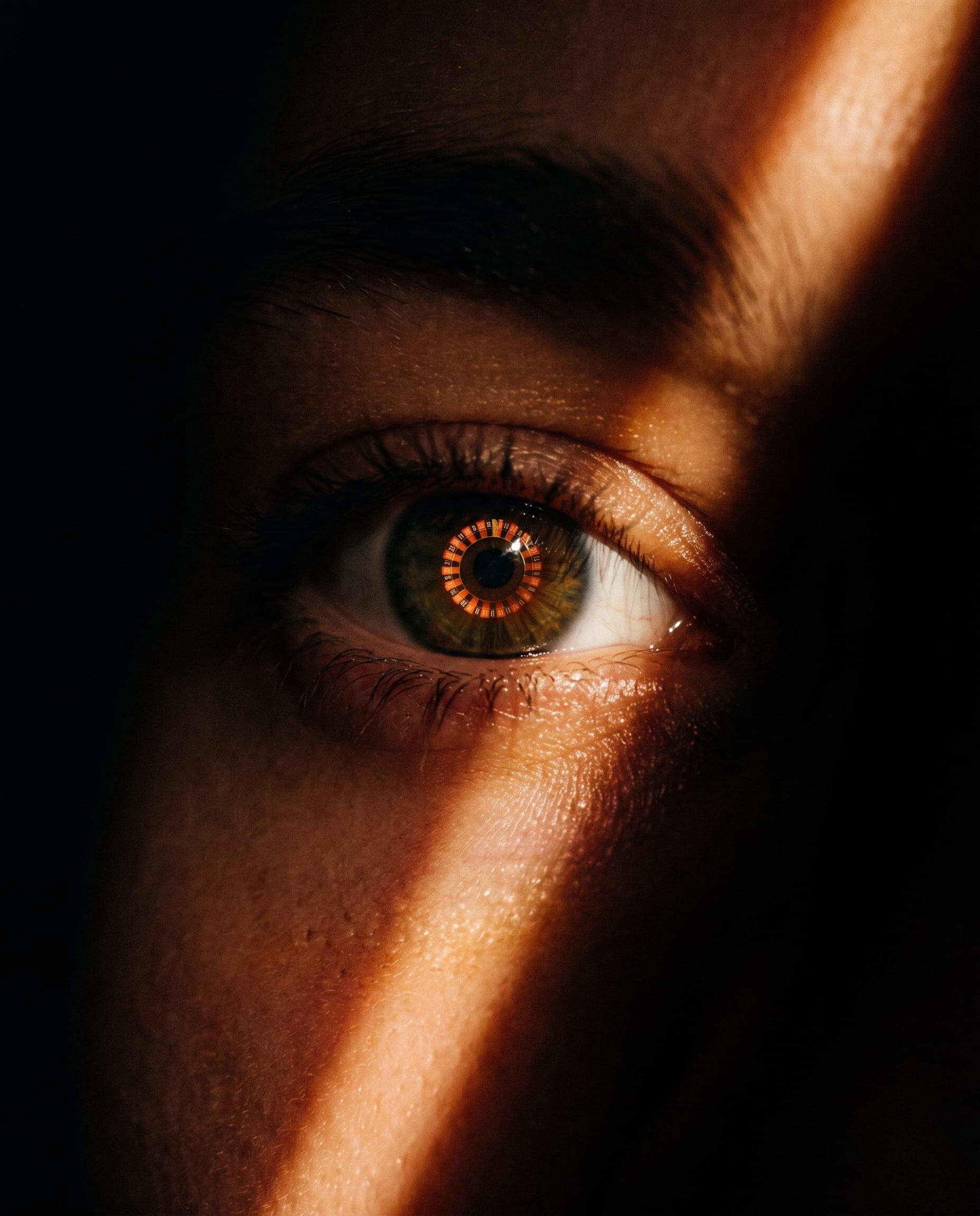 Close-up of an eye reflecting glowing roulette lights